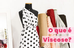 manequim vestido com tecido viscose de fundo branco e poas pretos ao lado de rolos de tecido