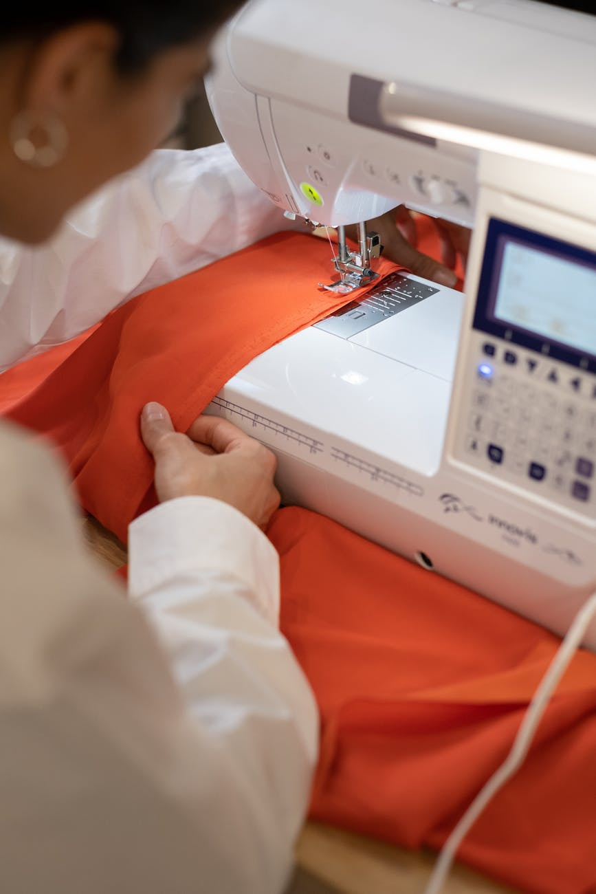 mulher costurando em máquina de costura eletrônica